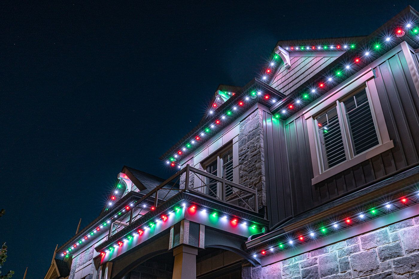 Home at night with permanent holiday roofline lighting